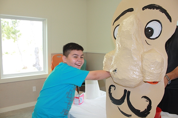 boy laughing at nose at camp