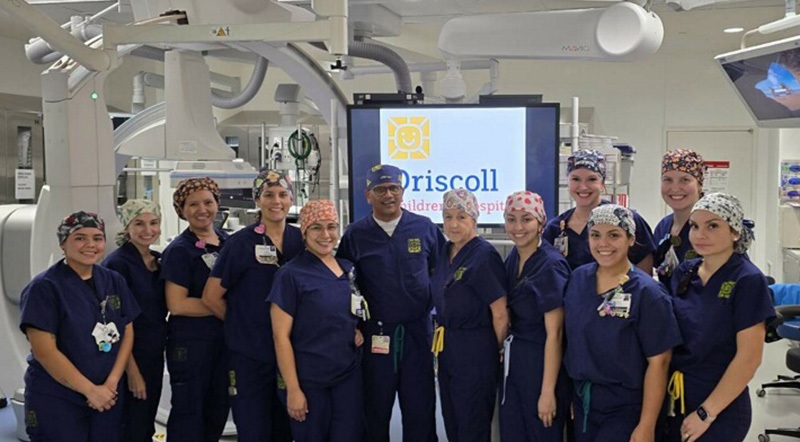 Interventional cardiology team in the diagnostics room wearing their blue scrubs.