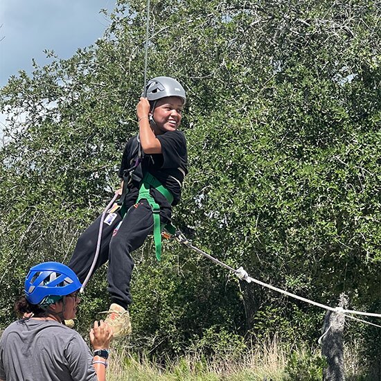 Boy zip lining at camp.
