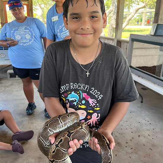 Smiling boy holding a snake.