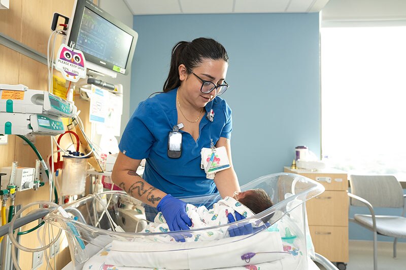 Nurse caring for a newborn after labor in a hospital room.