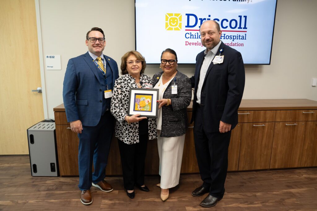 four people stand in a photo celebrating a donation